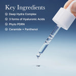 Close-up of a glass dropper releasing a clear, viscous serum droplet with a list of key ingredients like Hyaluronic Acid.