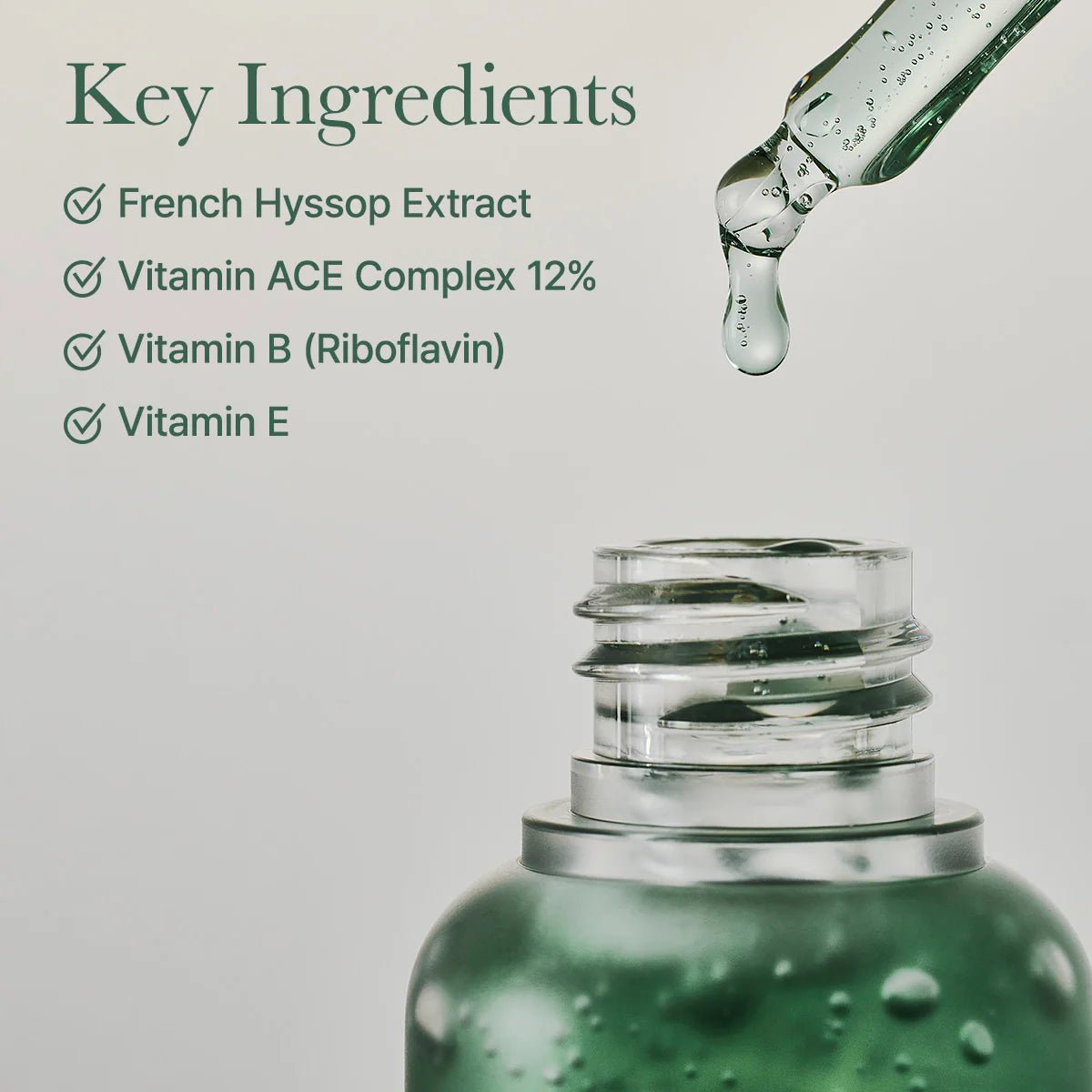 Green dropper bottle with a list of key ingredients on a light gray background