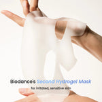 Hands holding a thick, white Biodance hydrogel mask for sensitive skin.