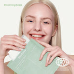 Smiling model holding the Biodance Sea Kelp Mask packaging.