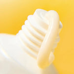 Close-up of a white light bulb against a yellow background