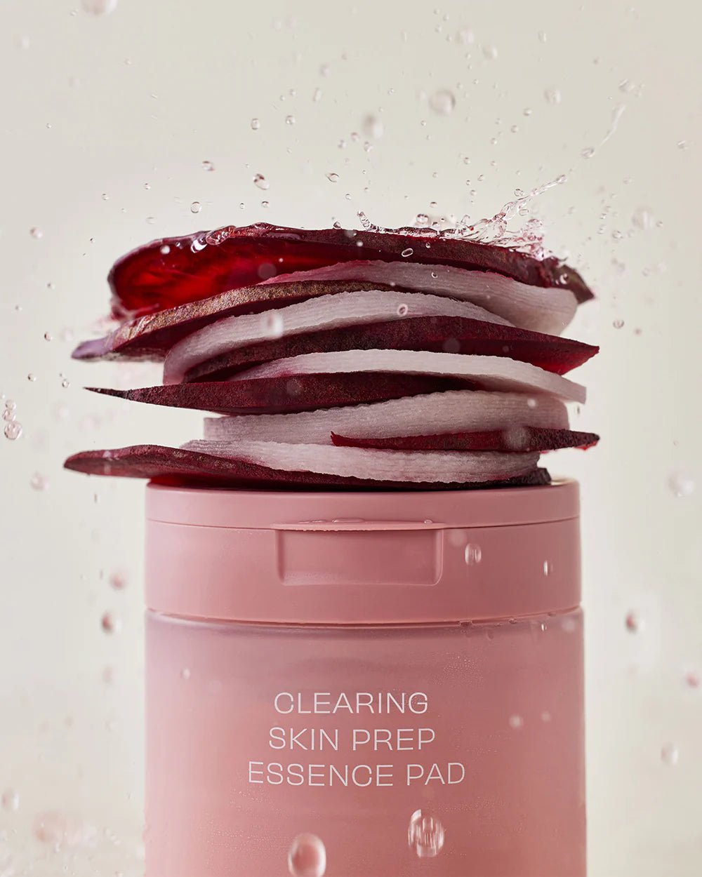 Fresh red beet slices stacked on top of House of Hur essence pad jar.