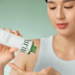 A woman applying the lightweight Purito Wonder Releaf Centella Toner to her hand for a skincare routine.