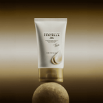 Skin1004 Madagascar Centella Teca Cream packaging balanced on a stone with a drop of white cream on the tube.