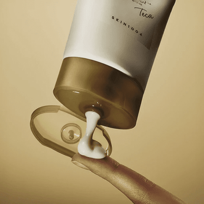 Skin1004 Madagascar Centella Teca Cream white tube with gold cap being squeezed onto a fingertip.