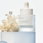 Skin1004 Matrixyl 10% Boosting Shot Ampoule bottle on a blue pedestal with white coral decor.