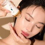 Close-up of a woman patting the soothing Mixsoon Soondy Essence into her cheek for a glowing finish.