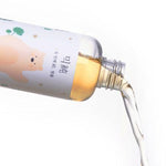 Mixsoon Soondy Centella Asiatica Essence pouring from a clear bottle showing its lightweight amber texture.